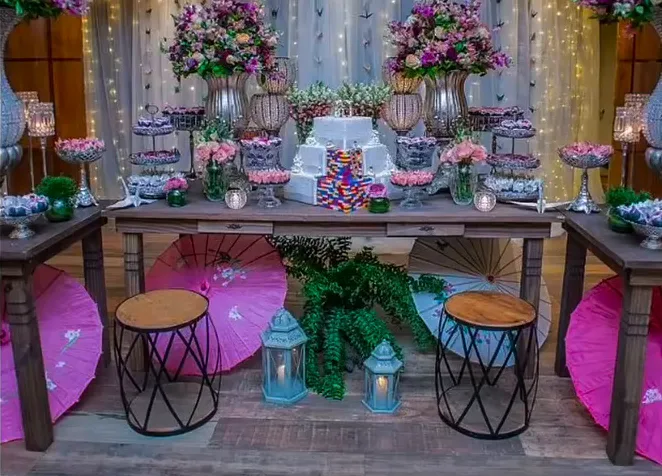 Mesa de festa decorada com flores, doces e bolo no Espaço Augusta.