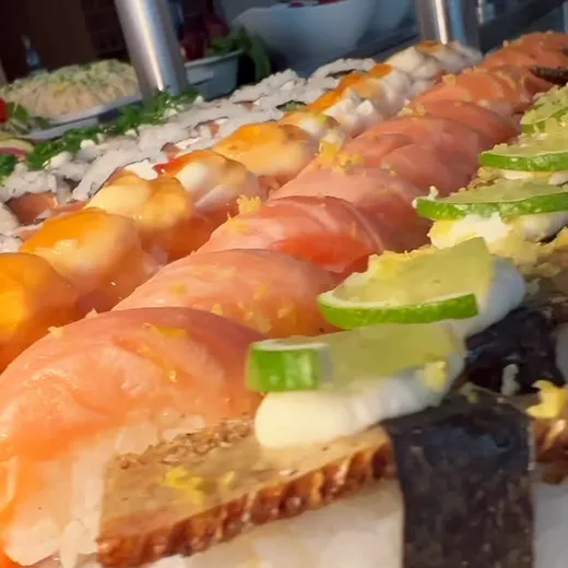 Fileira de sushis com limão e cebolinha.