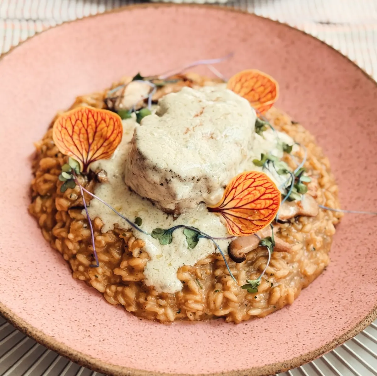 Risoto com queijo brie e flores comestíveis.