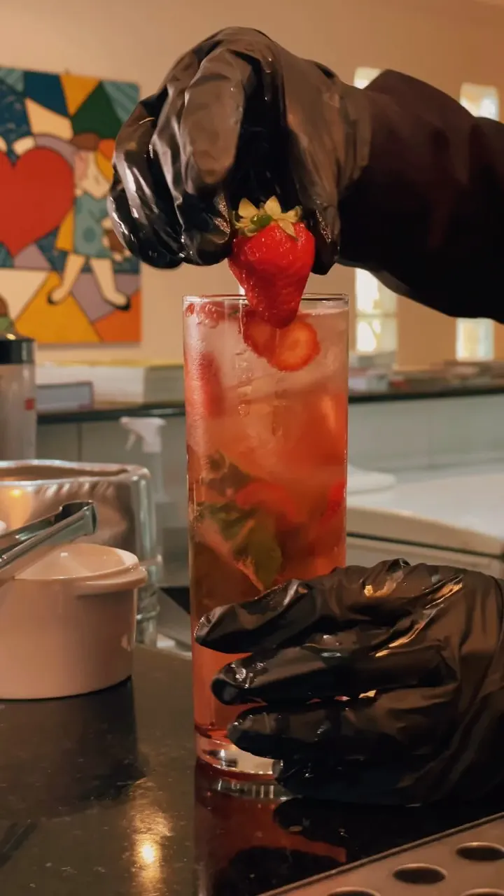 Drink de morango com gelo em copo alto.